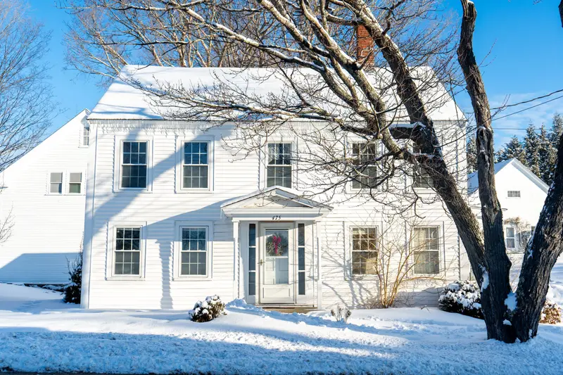 White New England colonial house in fresh snow.