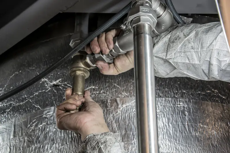 Gloved hands working on a pipe connection.