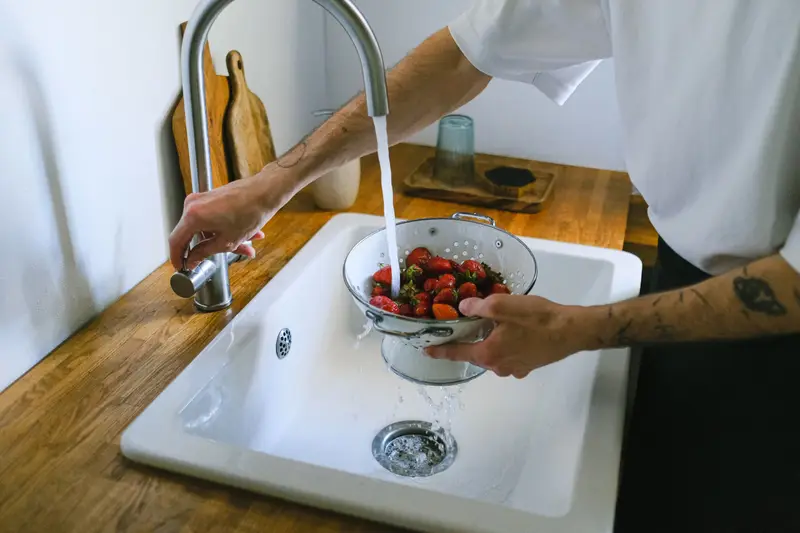 Water running freely into a white farmhouse sink.